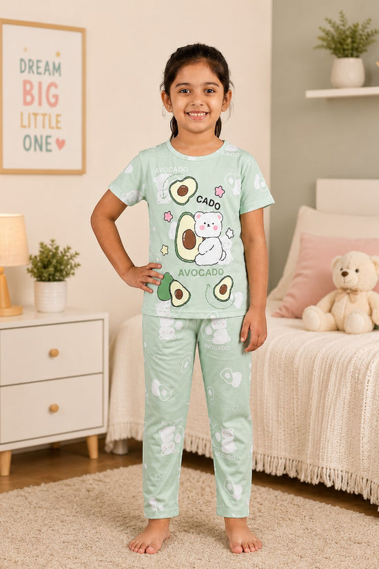 Chillpjs pastel green cotton night suit featuring a cute avocado and bear print worn by a young girl in a bedroom.