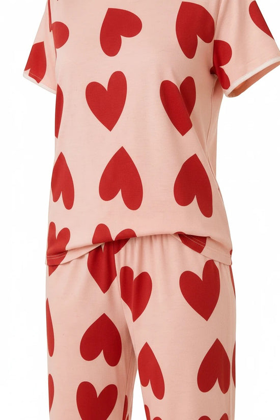 Chillpjs blush pink cotton pajama set with a bold red heart print, featuring a short-sleeve top and matching trousers.