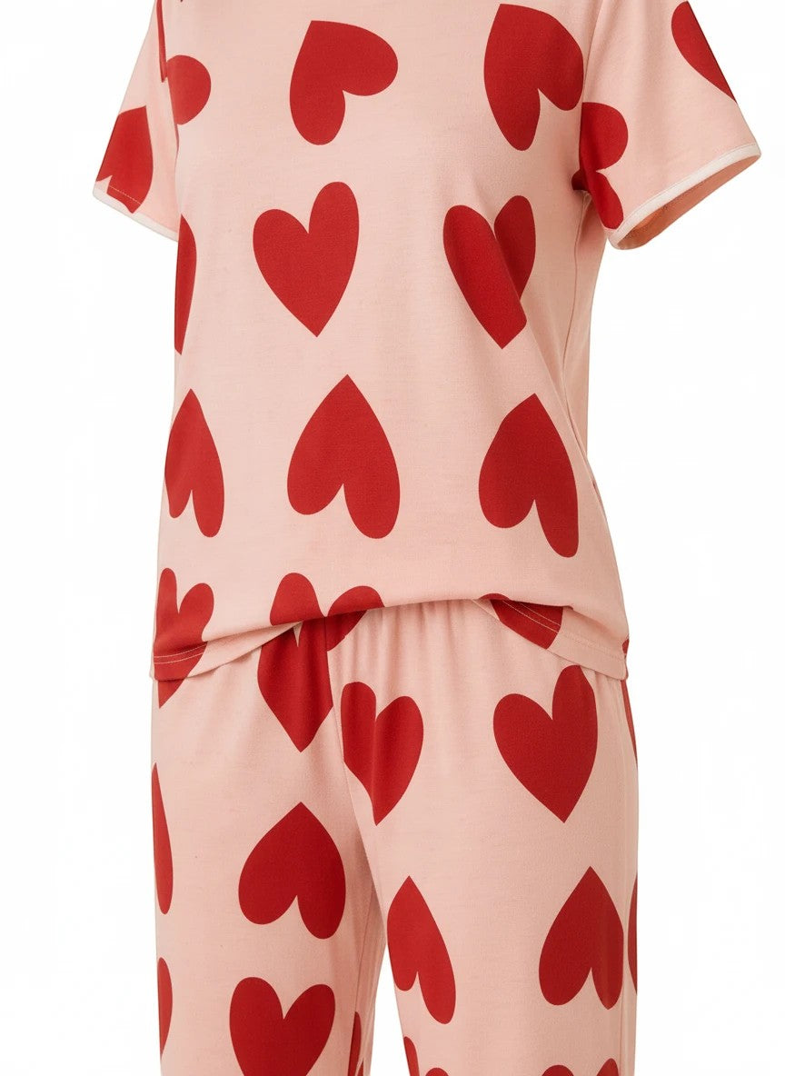 Chillpjs blush pink cotton pajama set with a bold red heart print, featuring a short-sleeve top and matching trousers.
