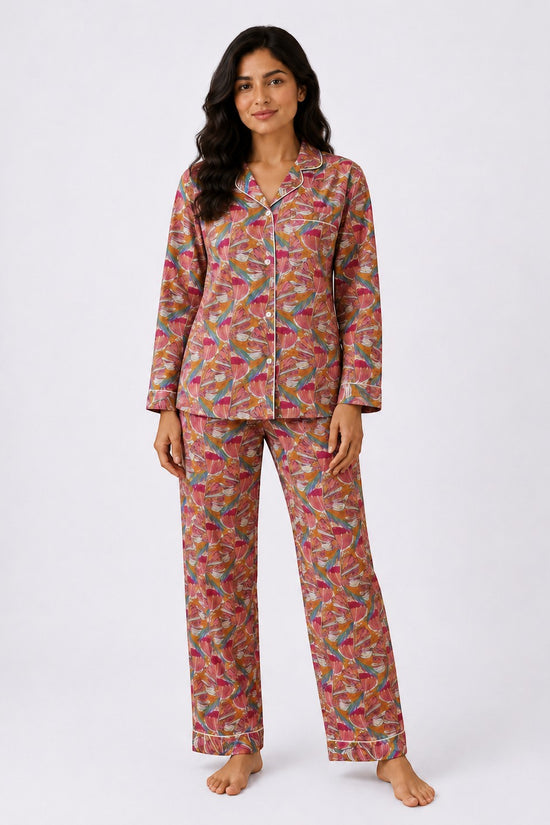 Woman wearing a Chillpjs Flora Muse linen night set with a vibrant multicolor floral print and contrast piping.