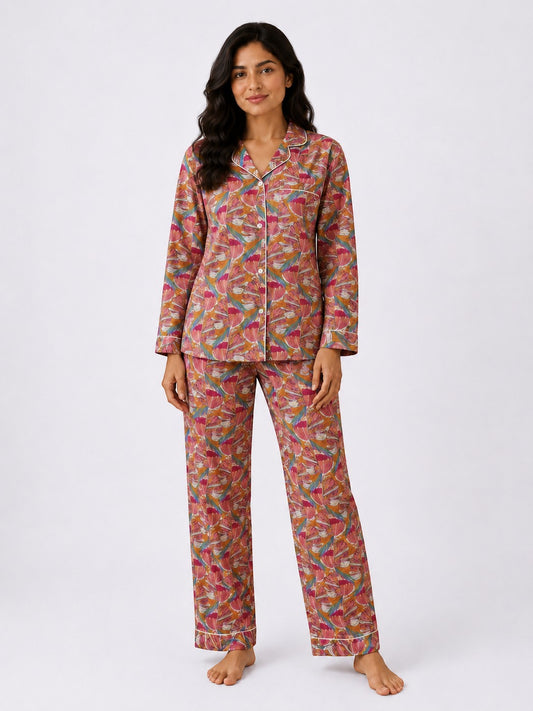 Woman wearing a Chillpjs Flora Muse linen night set with a vibrant multicolor floral print and contrast piping.