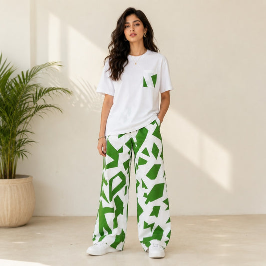 Model wearing Chillpjs Urban Pop lounge set with white t-shirt and green abstract print wide-leg trousers.