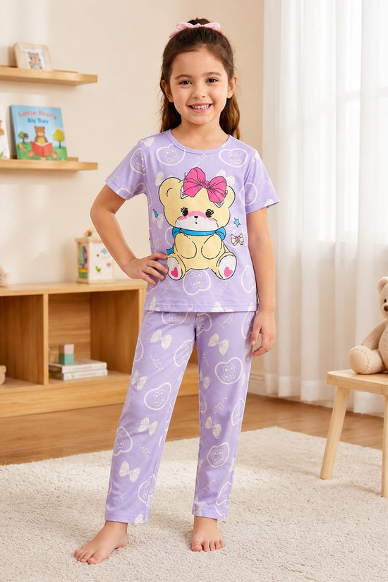 Chillpjs lavender cotton night suit with teddy bear print worn by a smiling girl in a cozy bedroom setting.