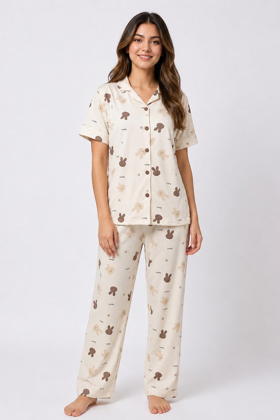 Model wearing Chillpjs Lucky Bunny short-sleeve pajama set in sandstone cream popcorn crinkle fabric with bunny print.