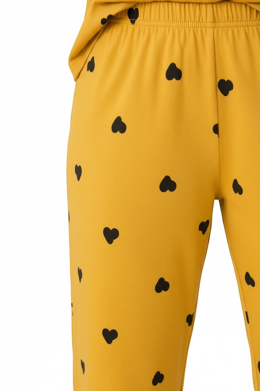 Chillpjs Sunny Hearts pajama trousers in marigold yellow with a scattered black heart print and elasticated waistband.