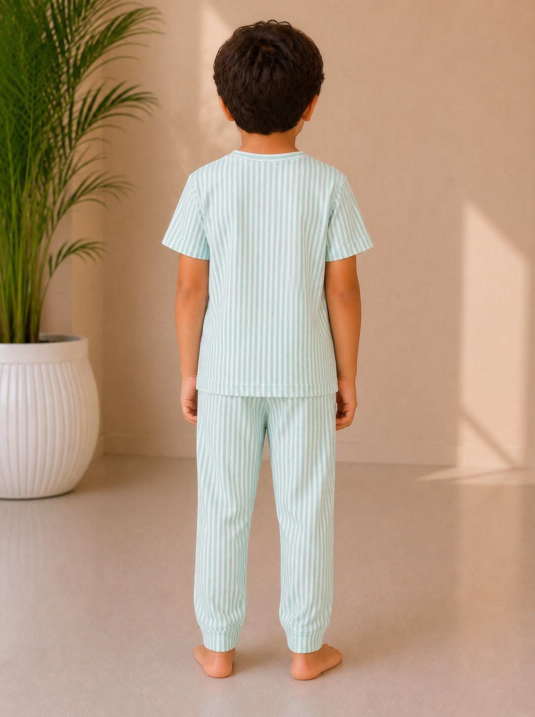 Back view of a child wearing a Chillpjs mint green and white pinstripe cotton pajama set with short sleeves and cuffs.