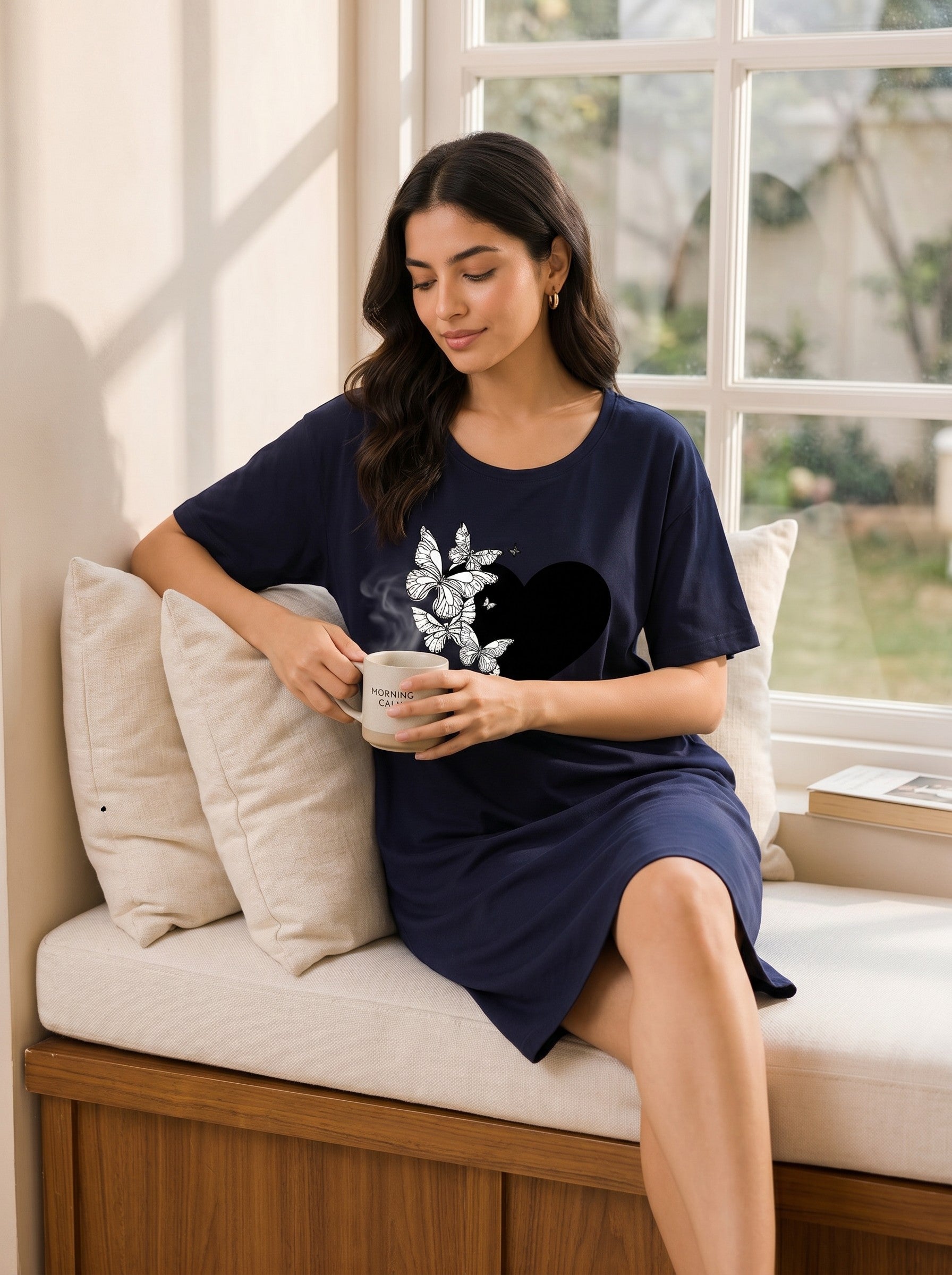 Chillpjs navy oversized t-shirt dress with a black heart and white butterfly graphic worn by a woman holding a mug