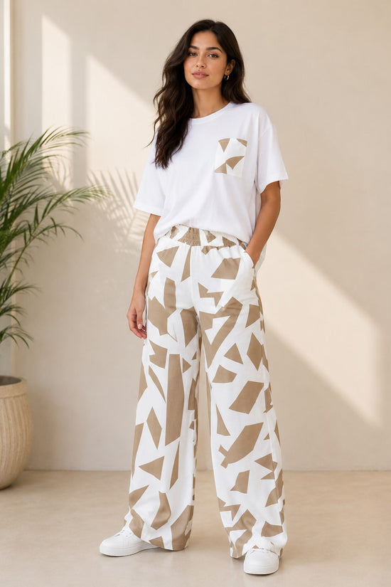 Chillpjs Urban Pop lounge set featuring a white relaxed-fit t-shirt and wide-leg trousers with a beige abstract print.