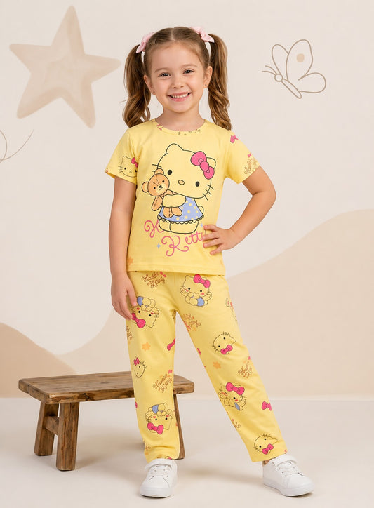 Young girl smiling in a Chillpjs yellow Hello Kitty cotton pajama set with short sleeves and matching trousers.
